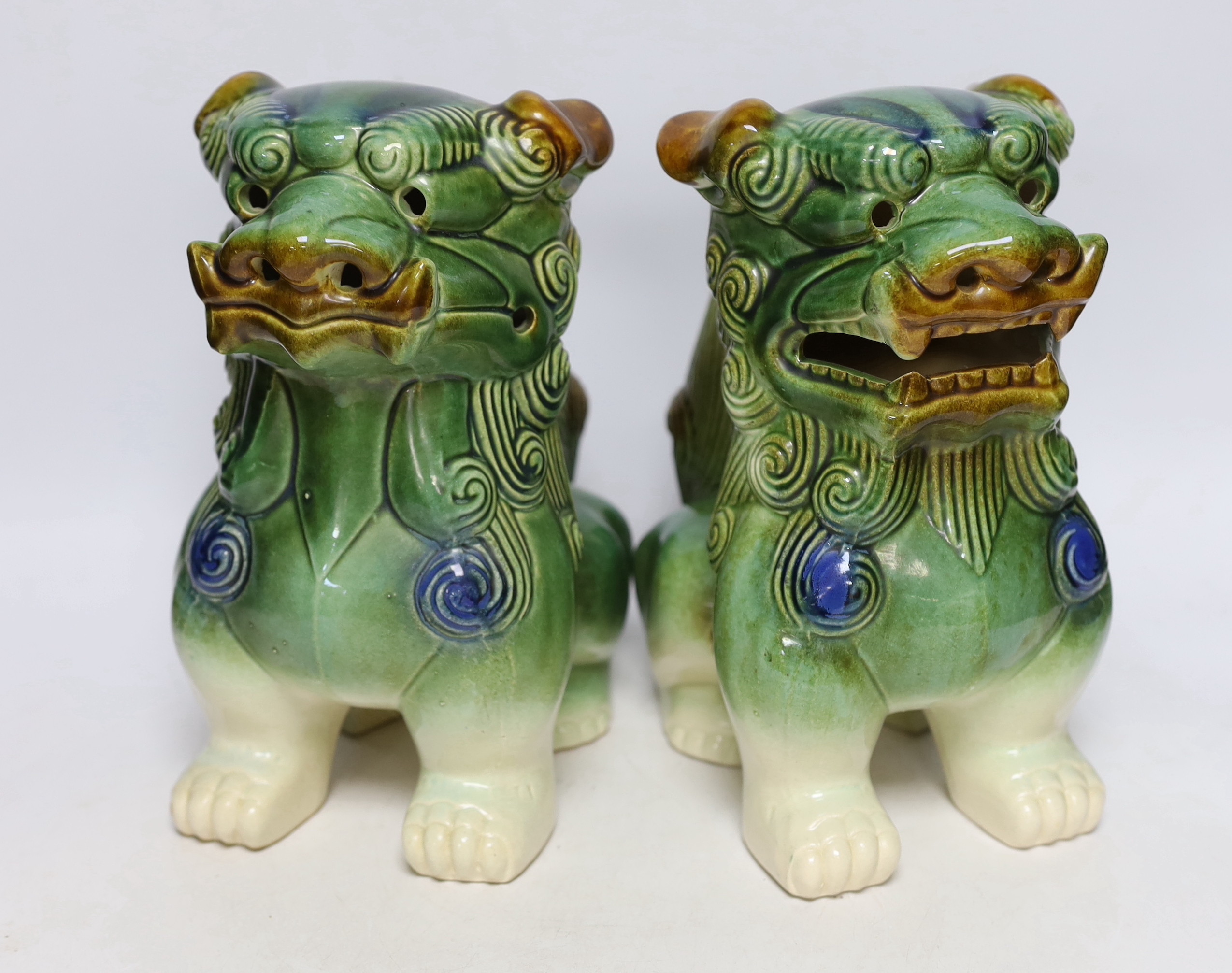 Two Chinese blue and white with iron red ‘dragon’ vases and a near pair of lion dogs, tallest 26cm